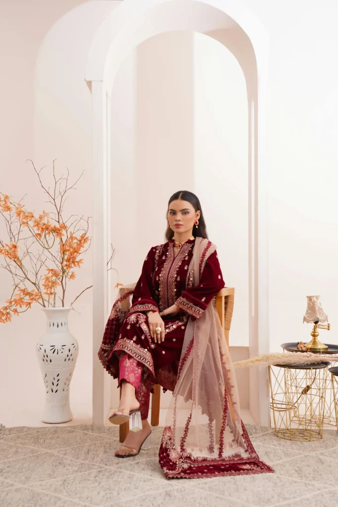 A lady wearing churidar and sitting a chair